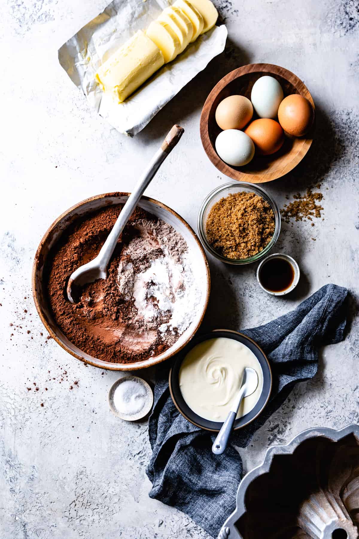 ingredients for Gluten Free Chocolate Bundt Cake Recipe are arranged on a gray surface