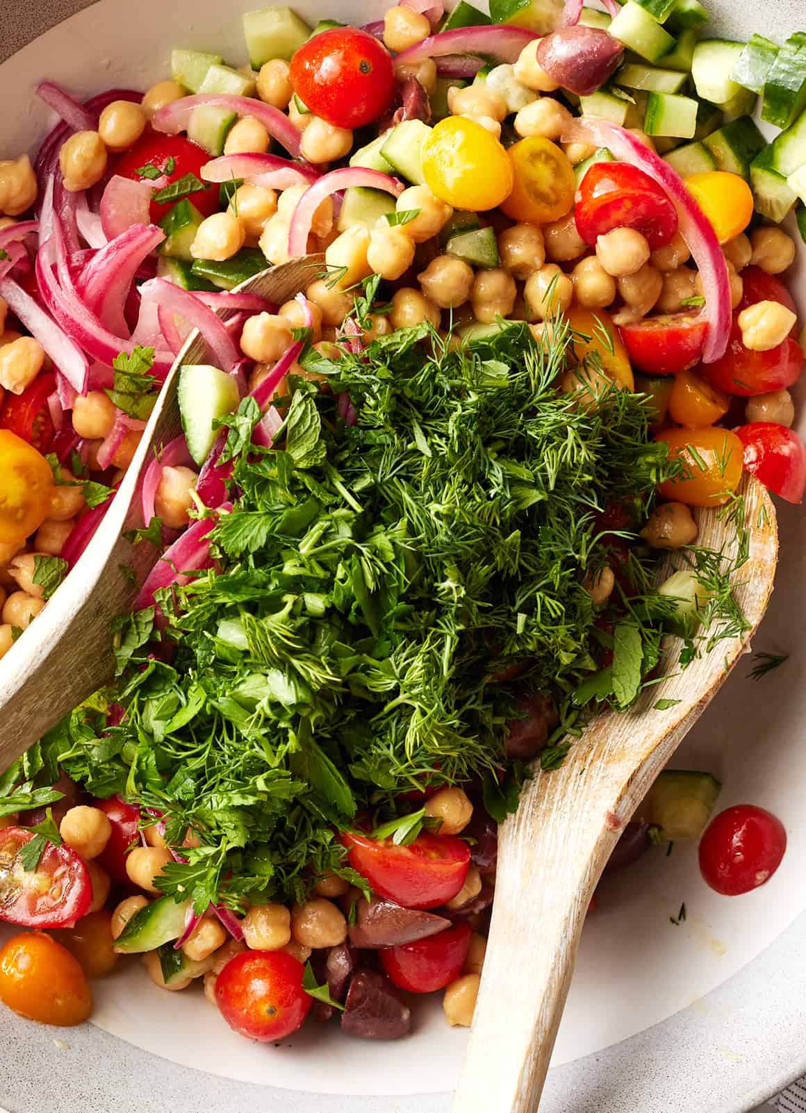Adding herbs to chickpea salad