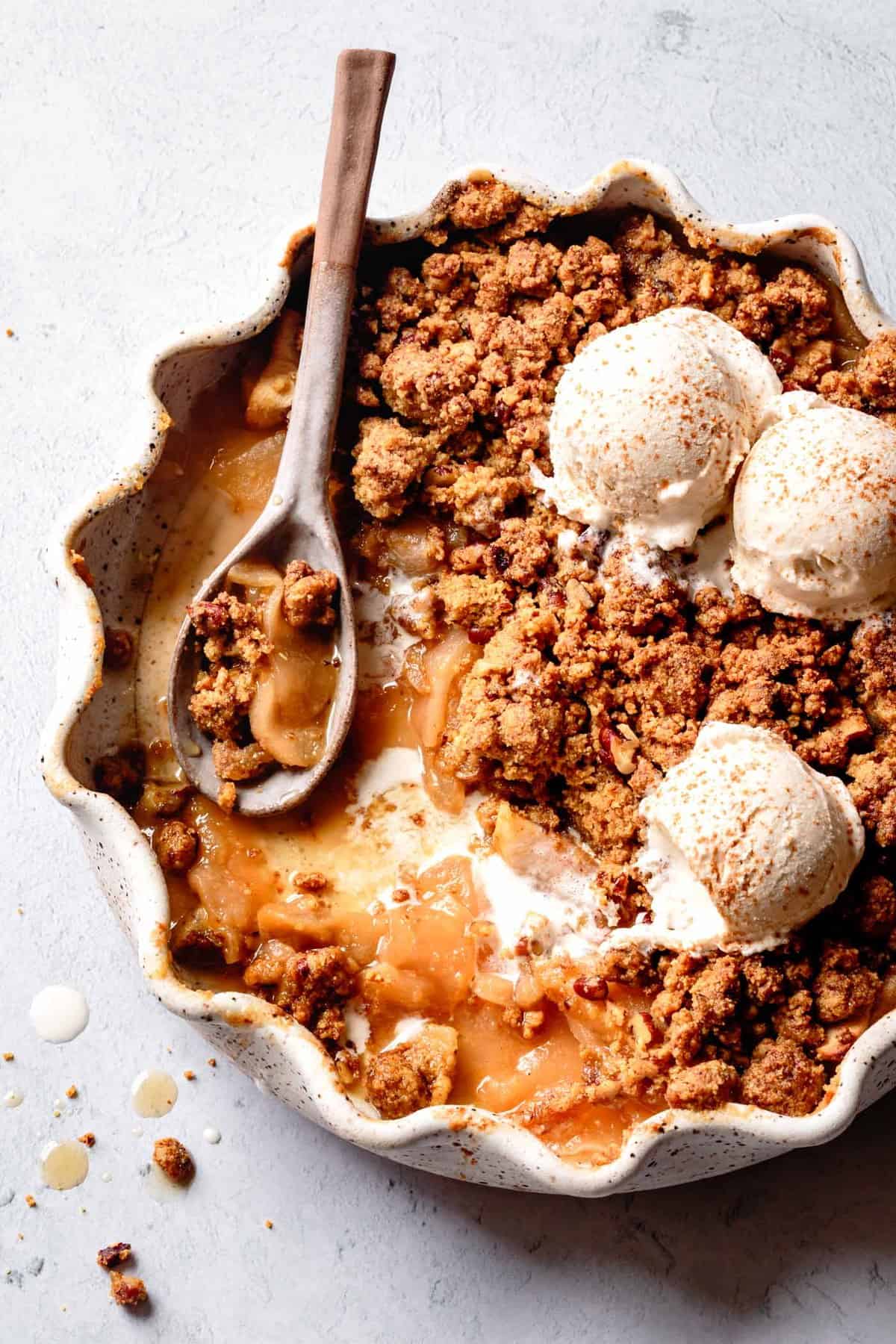 almond flour apple crisp baked in a pretty dish with ice cream on top